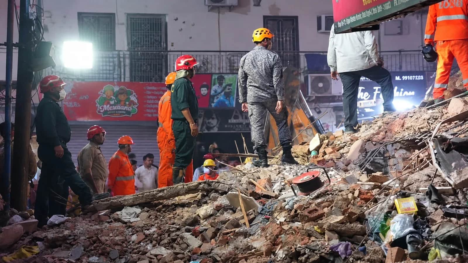 मलबे में बचावकर्मी तलाश करते हुए